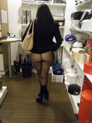 Sultry amateur babe lifts up her skirt to show her legs and bum in black pantyhose in the supermarket